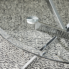close up of round glass coffee table top and silver metal legs